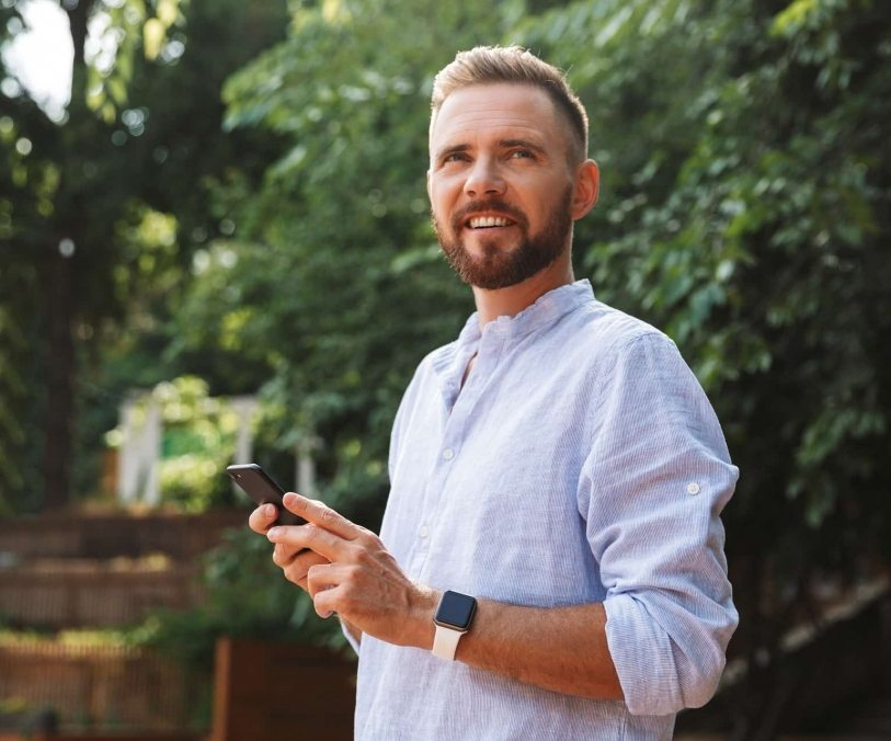 op_happy-young-bearded-man-outdoors-using-mobile-B9D43PN-813x676